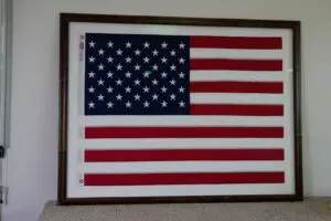 Framed American flag wall display in custom wooden frame