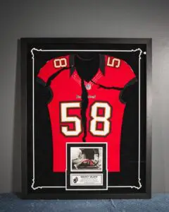 Red football jersey number 58 framed in sports memorabilia display
