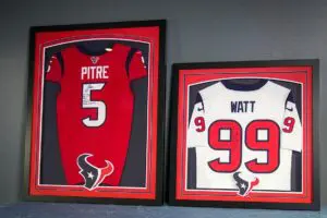 Custom framed red and white football jerseys numbered 5 and 99 displayed in shadow boxes