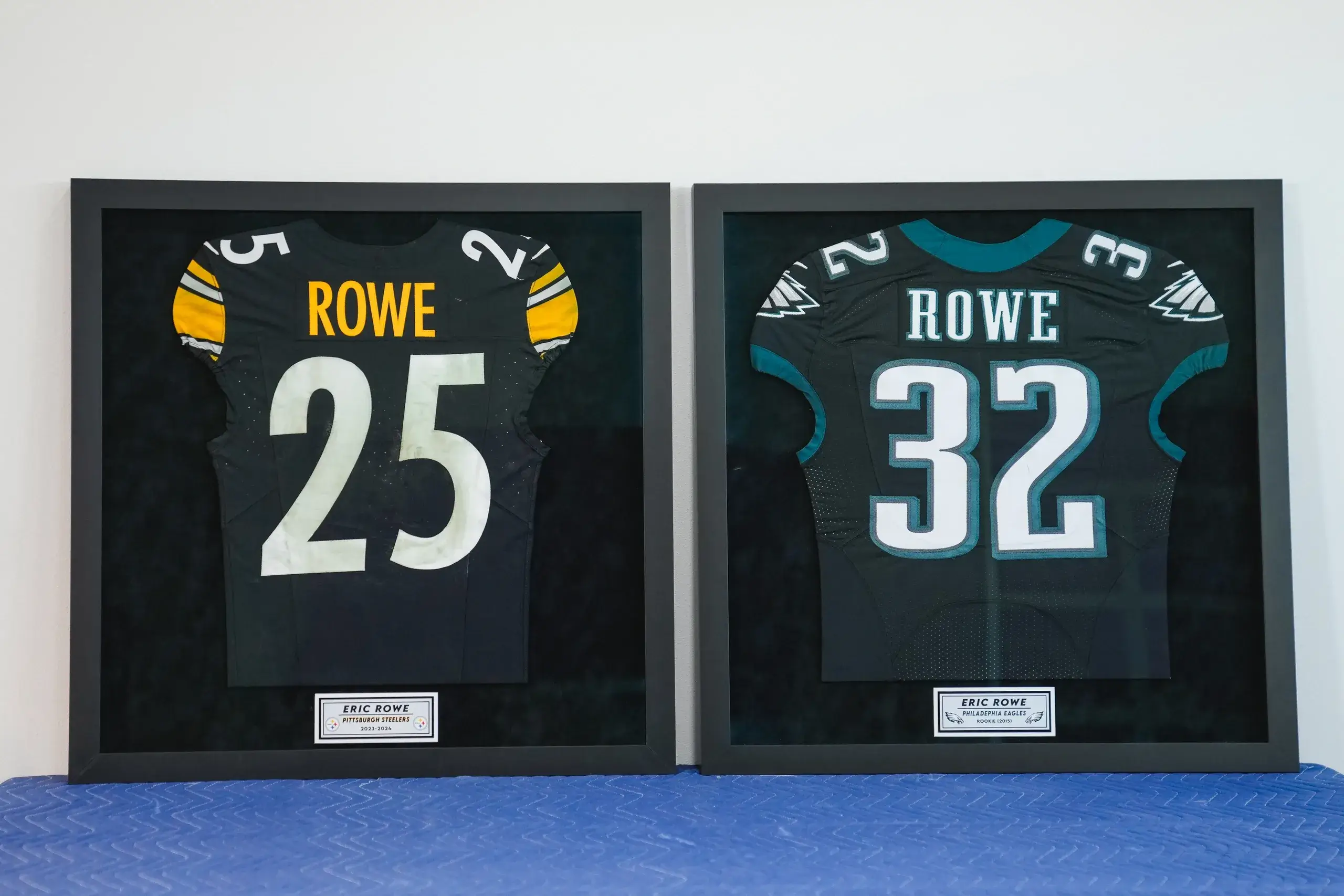 Two framed jerseys are displayed on a table.