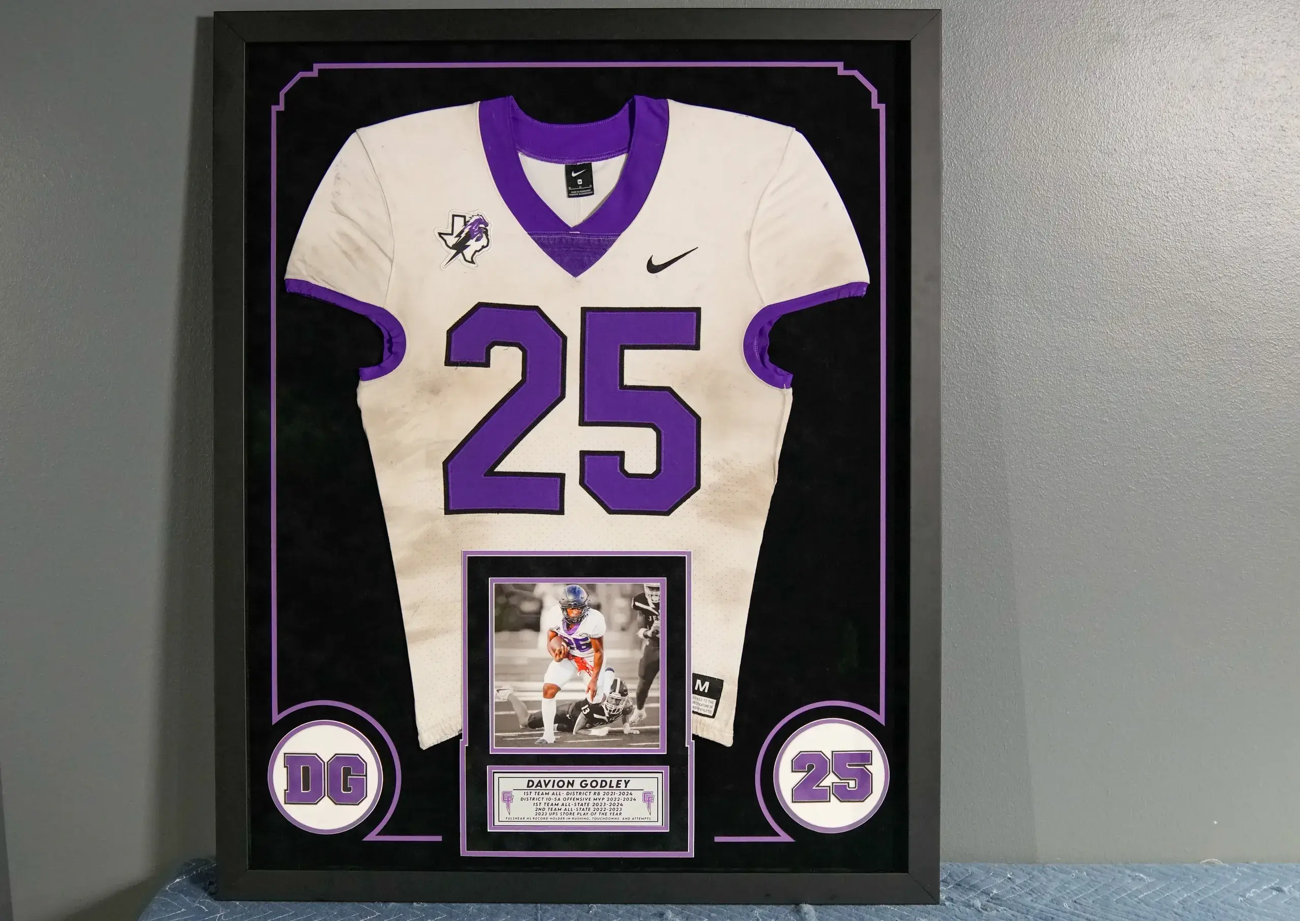 A framed football jersey with a plaque.