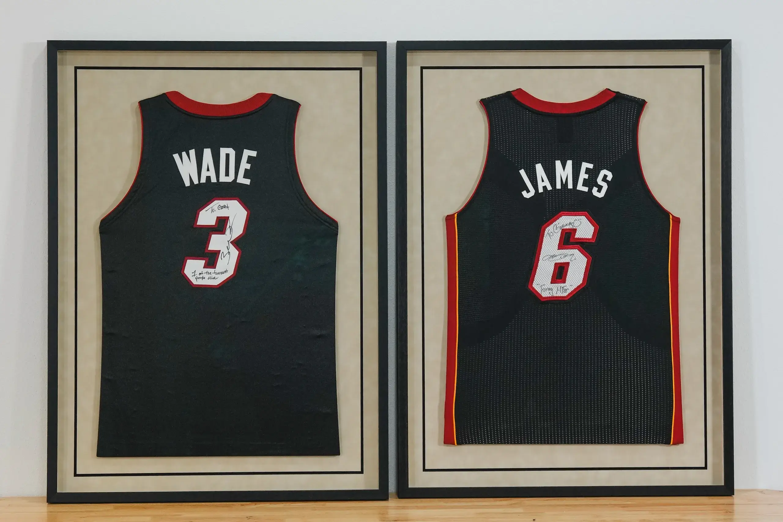 Two framed jerseys of wade and james are displayed.