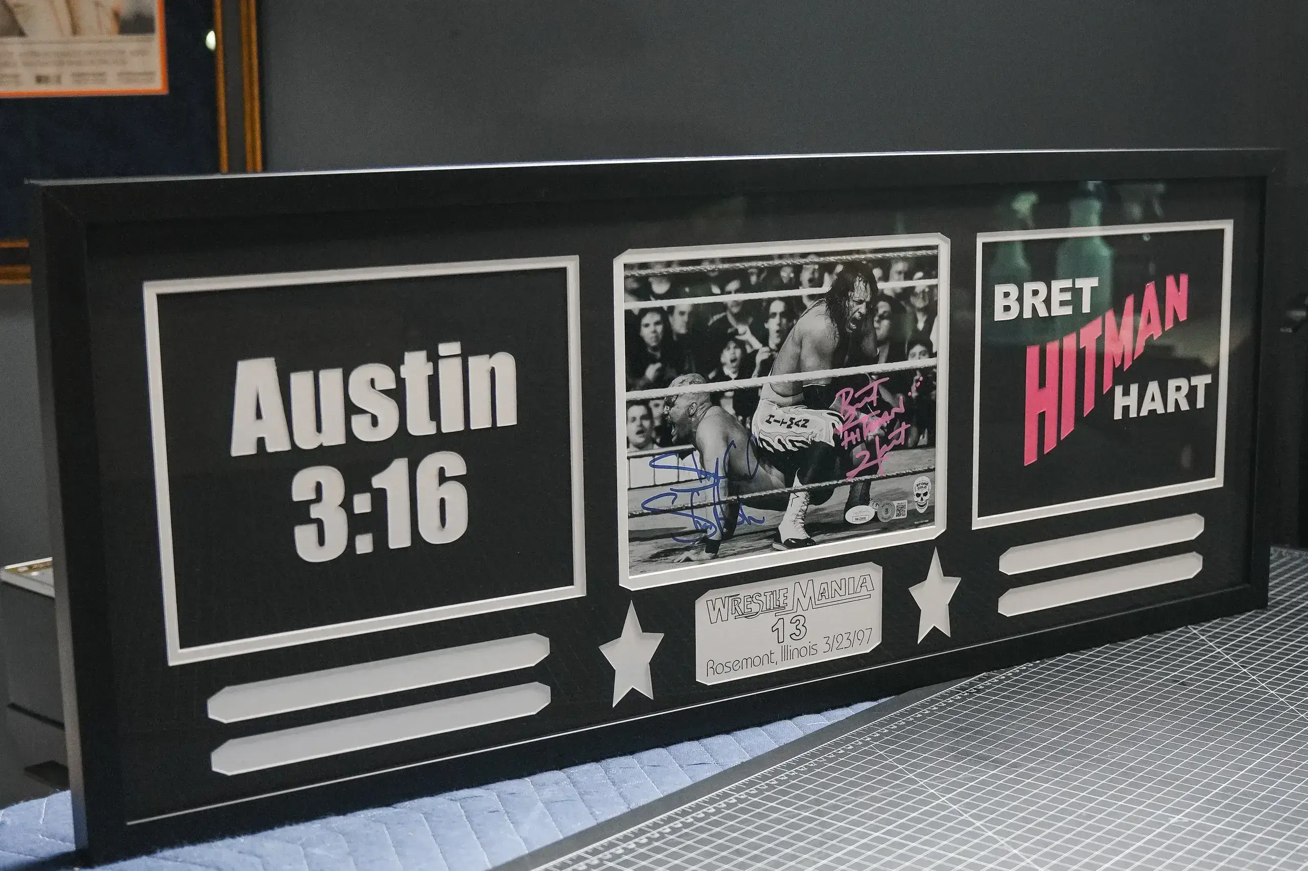 A picture of the austin 3 : 1 6 and bret hart autographed plaque.
