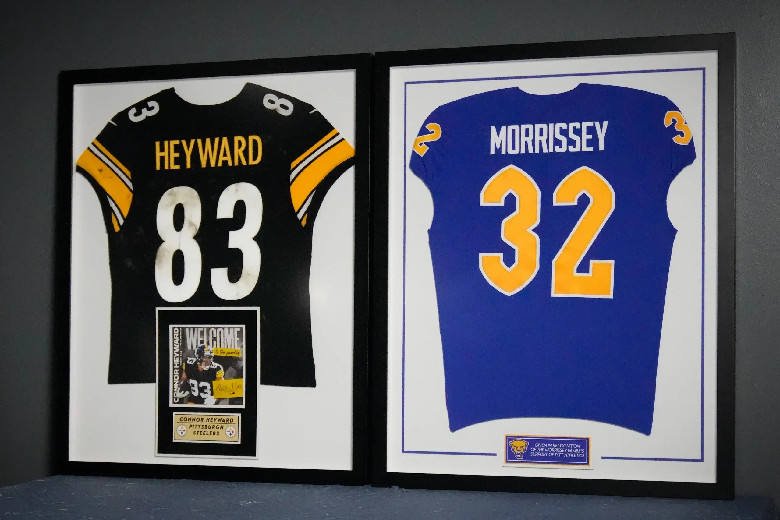 Two framed jerseys are displayed in a room.