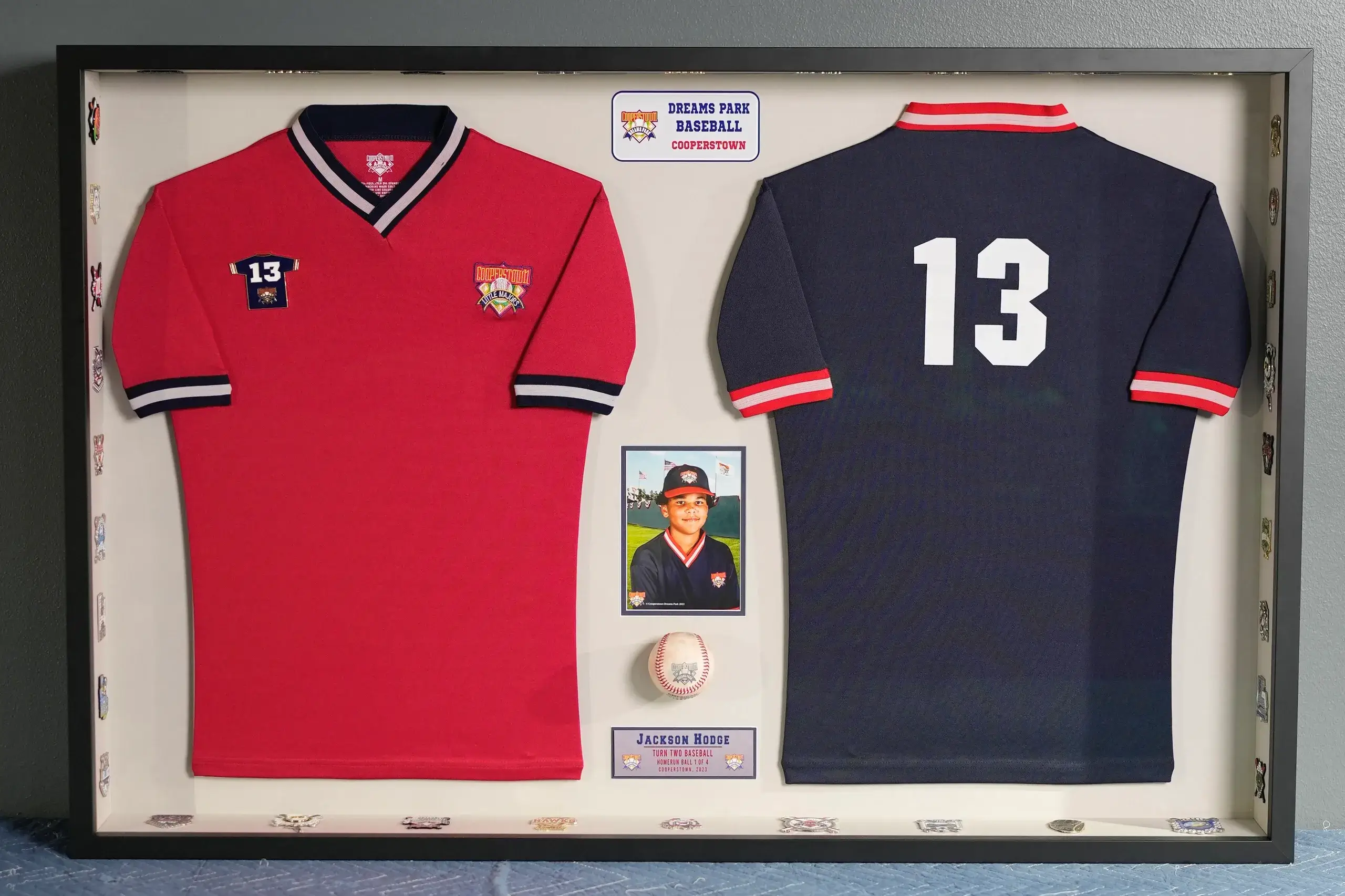 A framed baseball uniform and jersey with a photo of the pitcher.