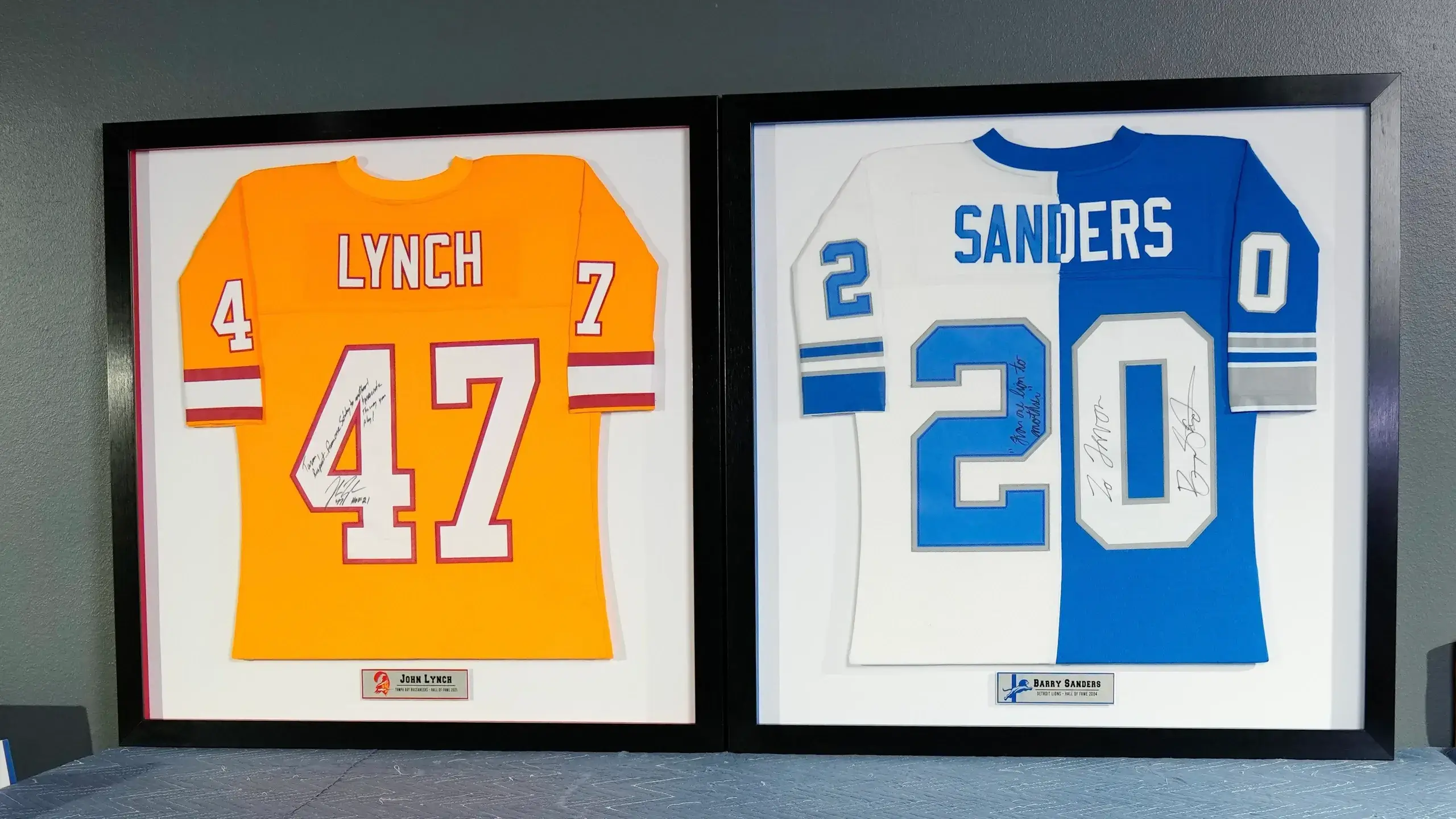 Two framed jerseys of football players are displayed.