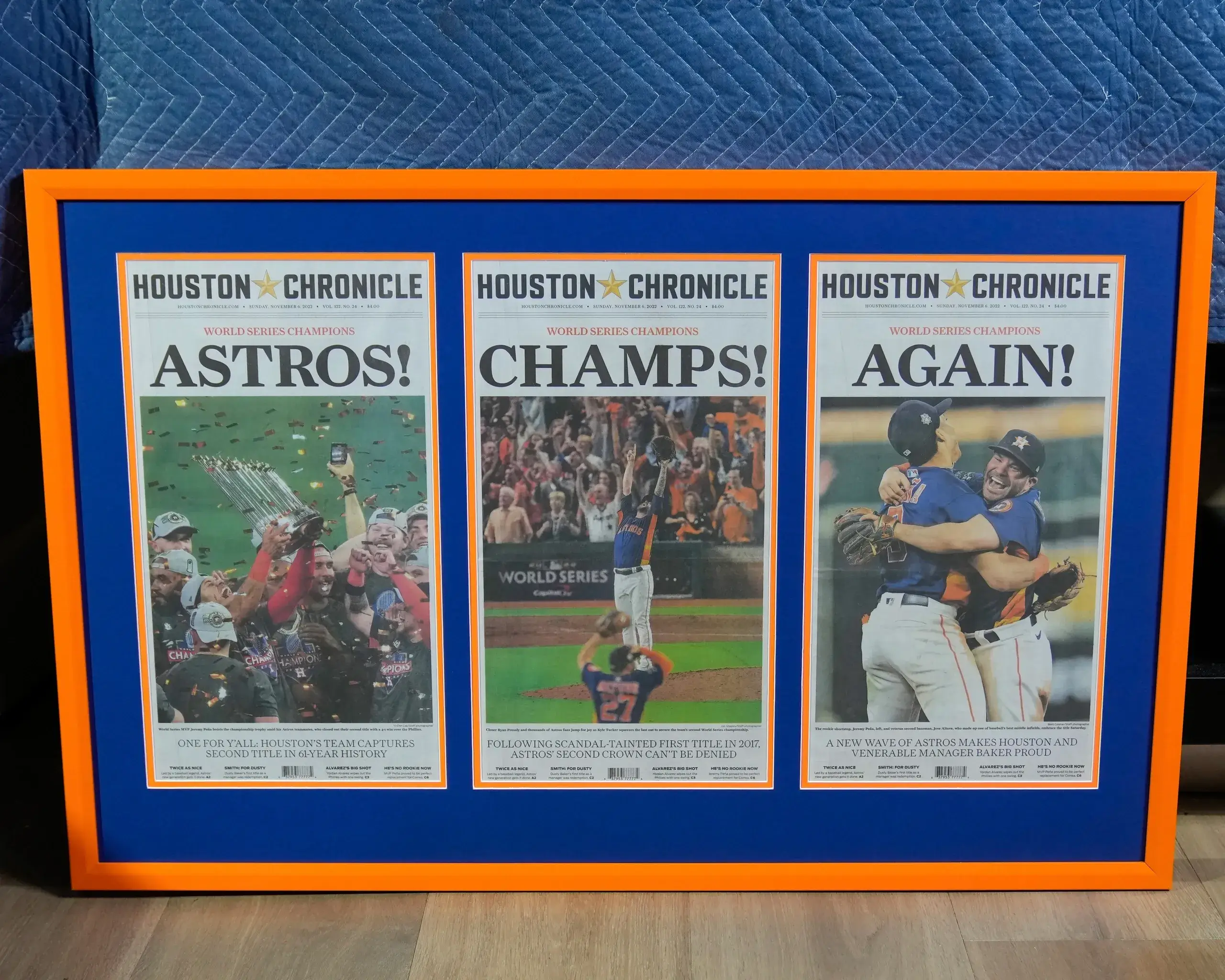 A framed newspaper with astros, champs and again on it.
