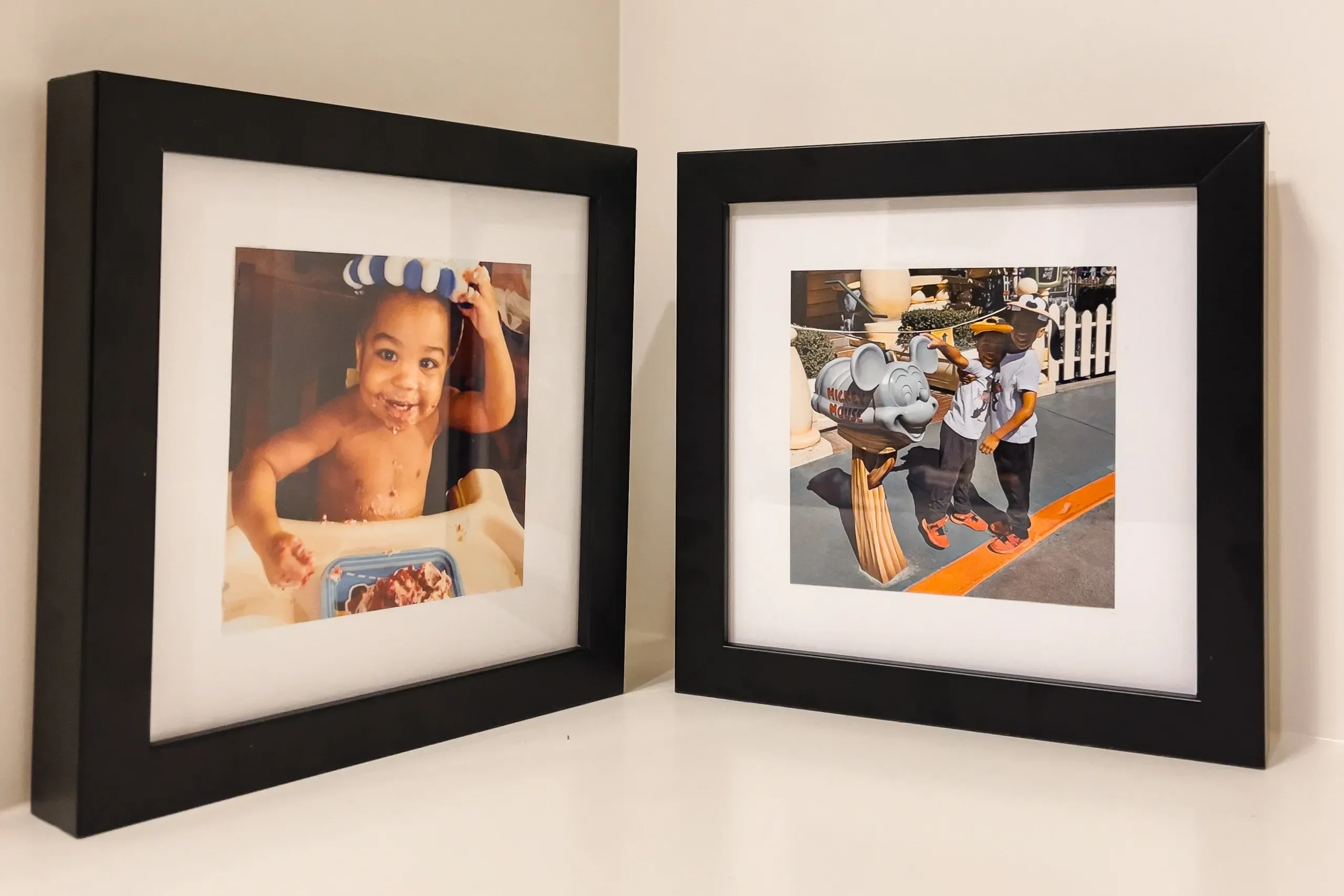 Two framed pictures of a baby and an adult.