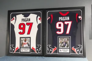 Framed white and black football jersey number 97 in display case