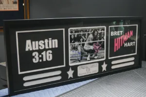 Framed wrestling memorabilia collage with bold text